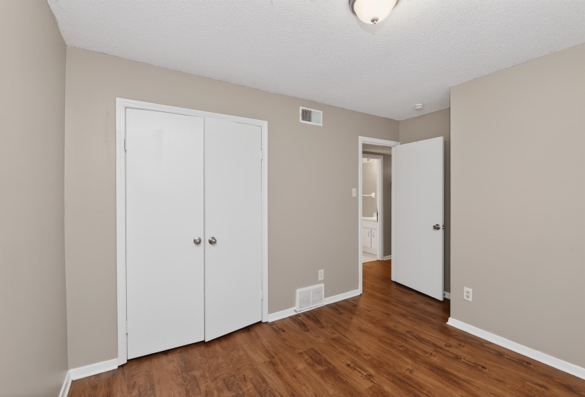 Room featuring wood-finish flooring, neutral wall paint, and white trim