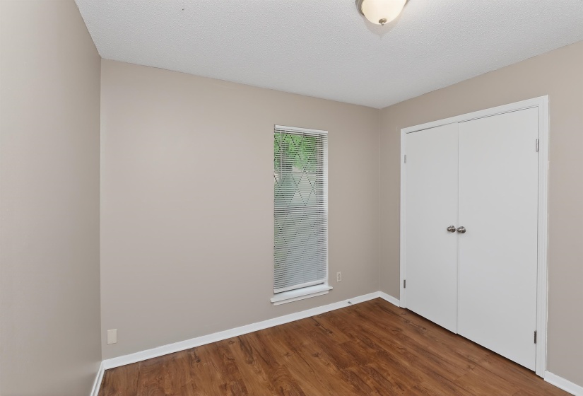 Spacious room featuring wood-finish flooring, neutral-toned walls, and white trim