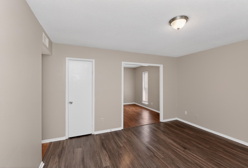 Interior room featuring wood-finish flooring, neutral wall paint, and white trim