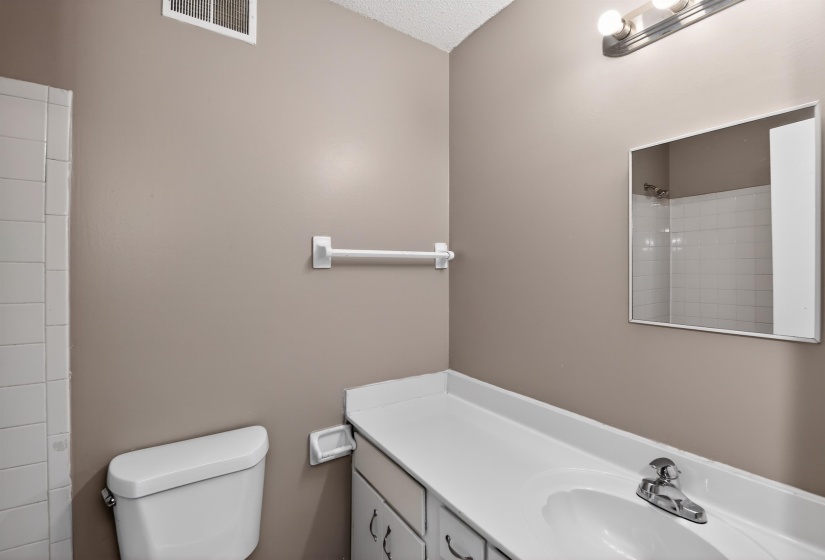 Bathroom vanity featuring a single basin sink and chrome faucet
