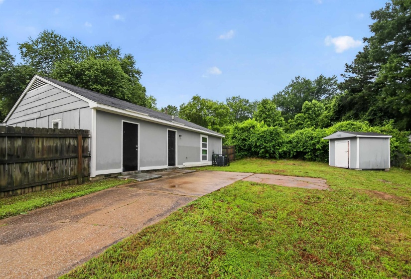 Gray exterior with black entry doors, a pitched roof, and a side-mounted HVAC unit