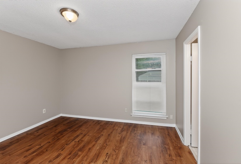 Interior room featuring wood-finish flooring, light gray walls, and white baseboards