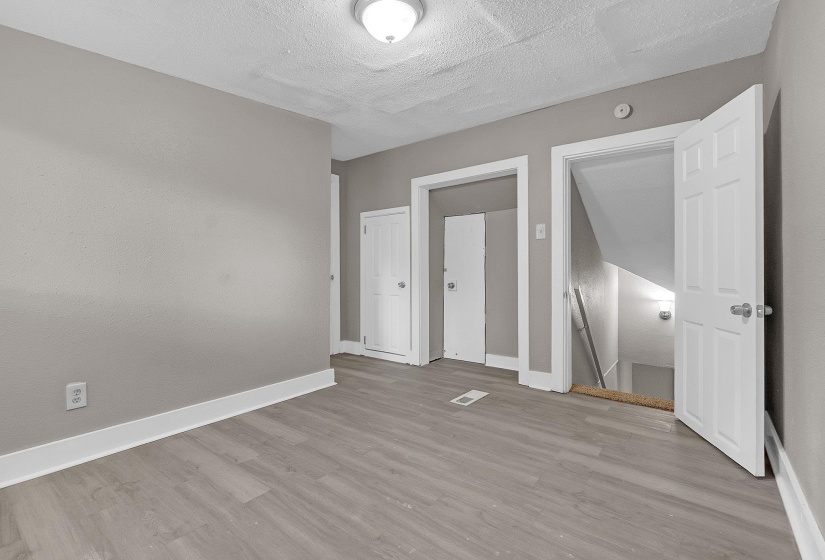 Interior room featuring wood-finish flooring, light gray wall paint, and white trim