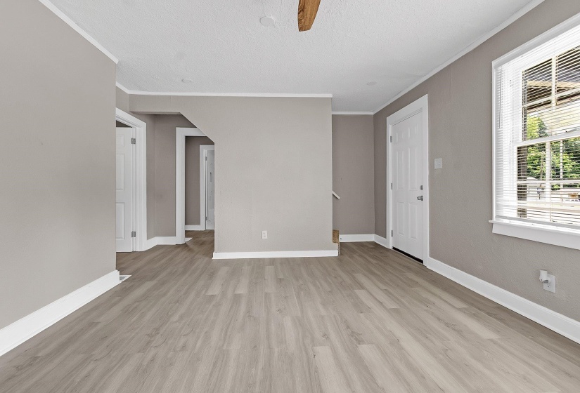 Interior space featuring wood-finish flooring, light gray wall paint, and white trim molding