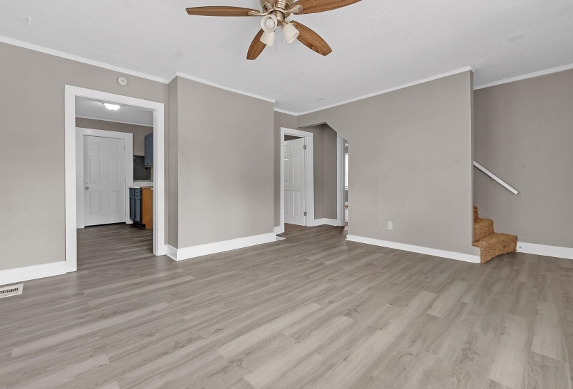 Spacious room featuring wood-finish flooring, neutral gray walls, and white trim