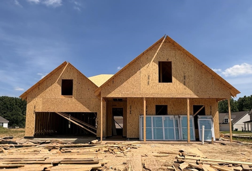 New construction in framing stage featuring a two-story design with prominent gables