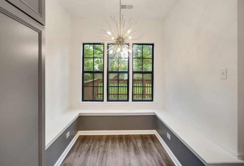 Built-in window seating with a white surface and dark gray lower wall paneling