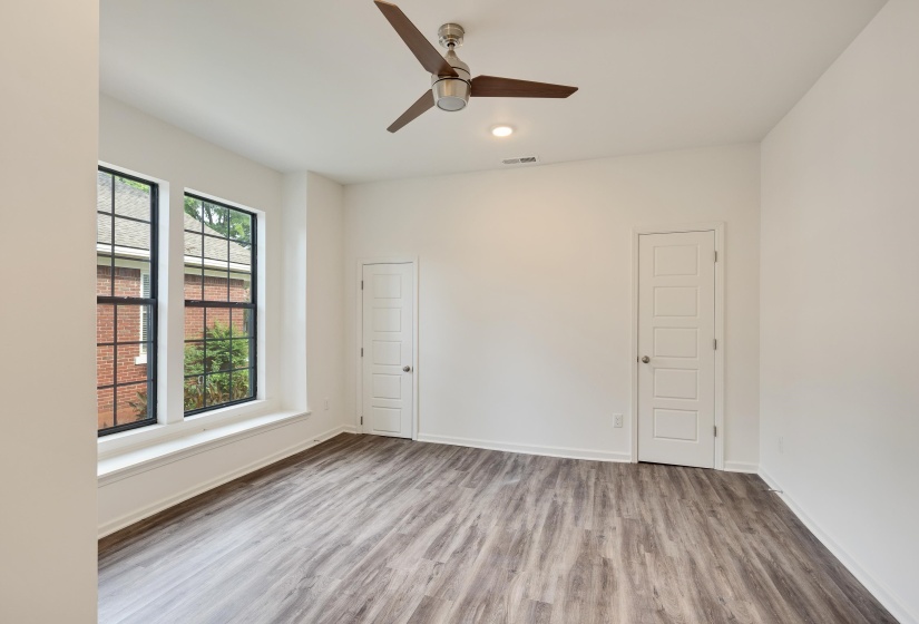 Spacious room featuring wood-finish flooring, a modern ceiling fan, and recessed lighting