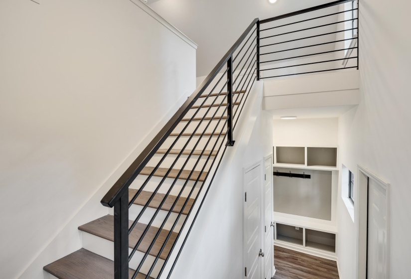 Modern staircase featuring black metal railings and wood-finish treads
