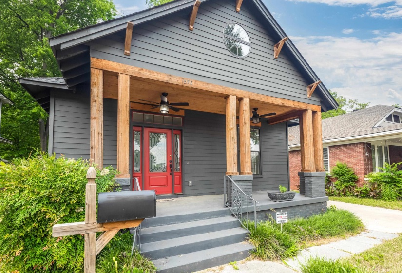 Craftsman-style facade with dark gray siding and natural wood columns