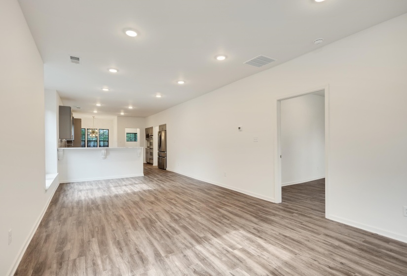 Spacious open-concept interior featuring light wood-finish flooring, recessed lighting, and a neutral color palette