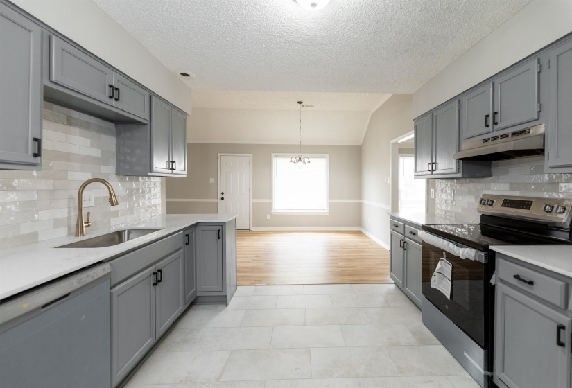 Contemporary kitchen featuring gray shaker-style cabinetry, white countertops, and a subway tile backsplash