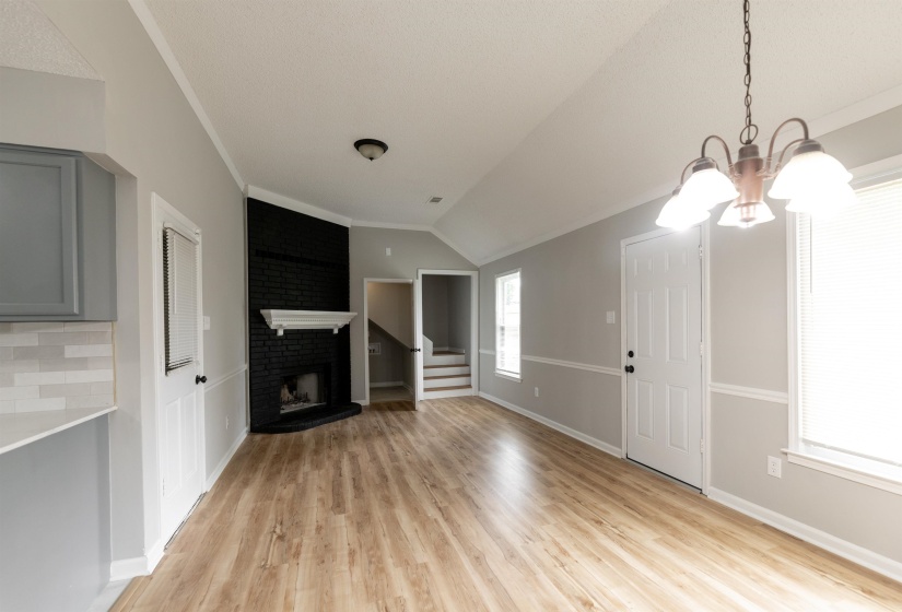 Open concept living space featuring wood-finish flooring and vaulted ceilings