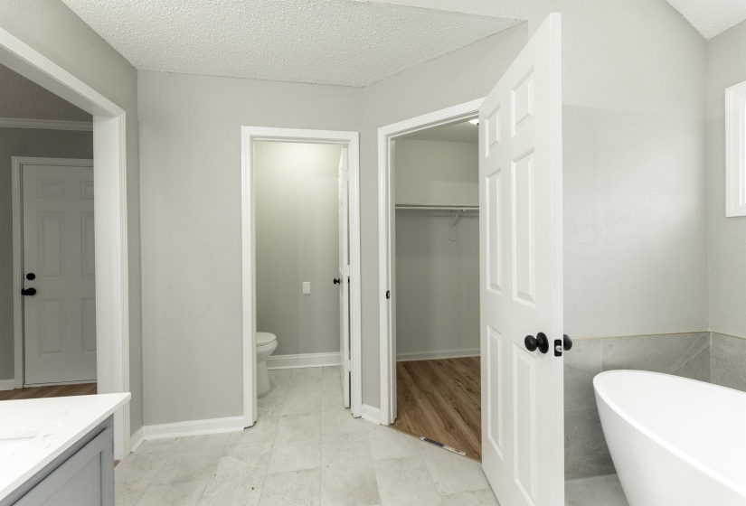 Freestanding soaking tub with light grey tile surround