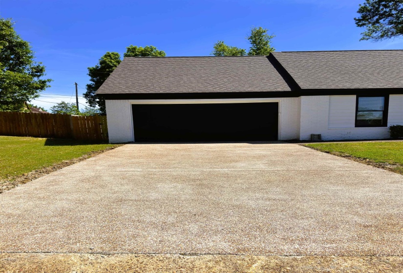 White brick exterior with a dark shingle roof and contrasting black trim