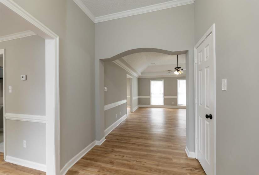 Entryway featuring wood-finish flooring, light gray wall paint, and white crown molding