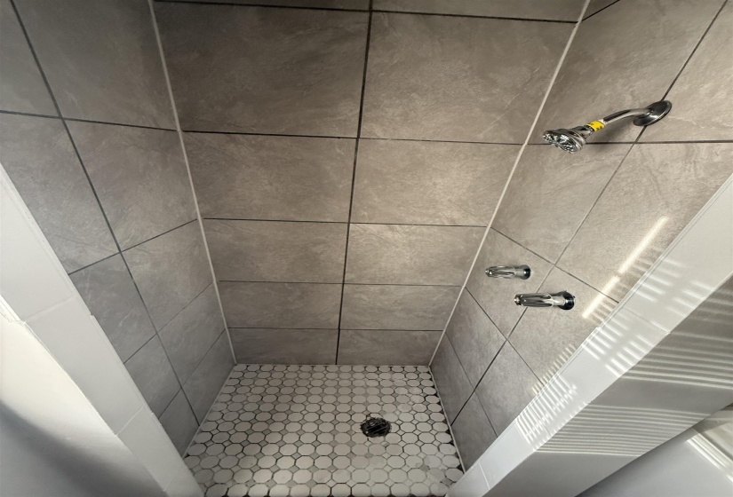Full bathroom featuring a shower stall