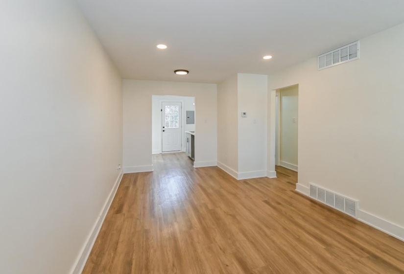 Spacious room with wood-finish flooring, recessed lighting, white baseboards, and neutral wall tones