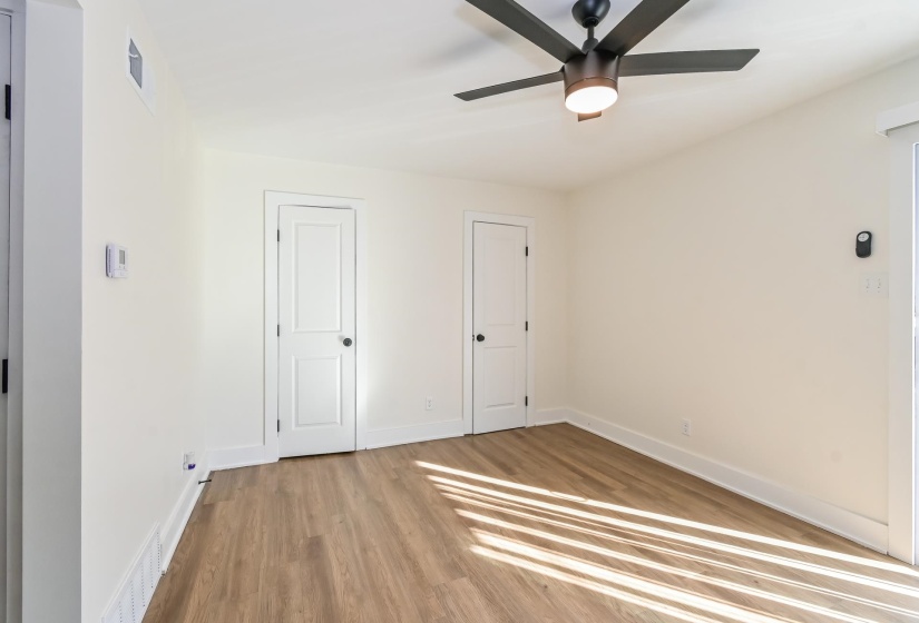 Room featuring wood-finish flooring, white walls, and a contemporary ceiling fan