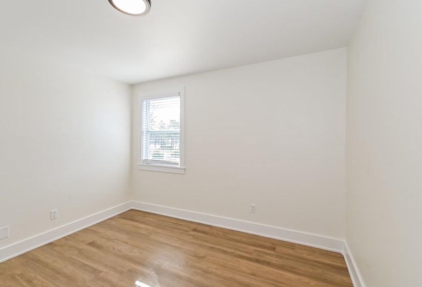 Interior space featuring wood-finish flooring, white baseboards, and neutral wall tones