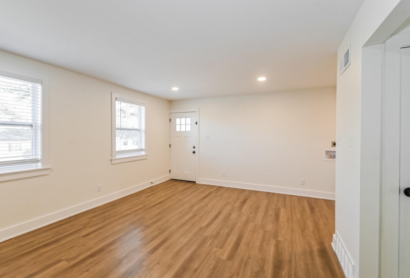 Light-filled room featuring wood-finish flooring, recessed lighting, and crisp white trim