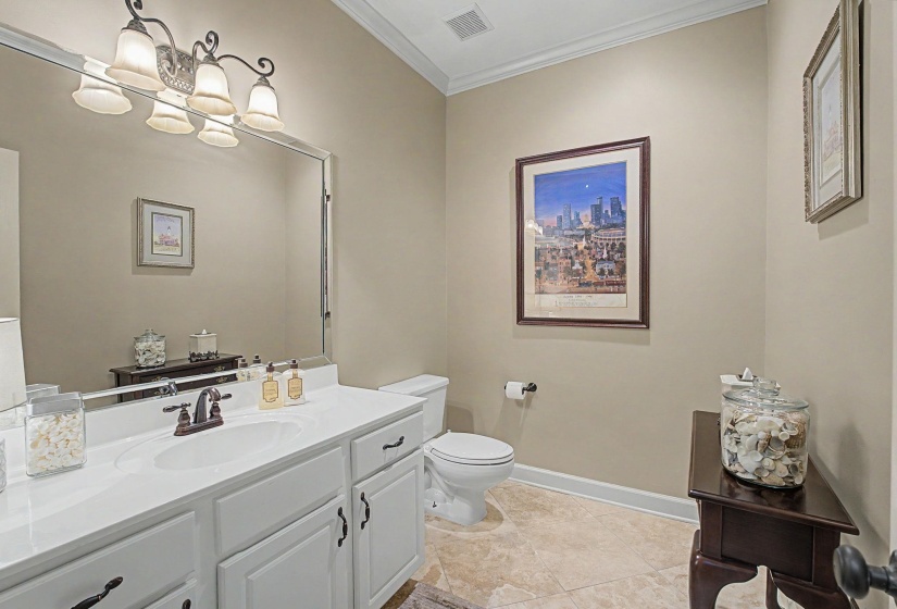 White vanity with an integrated sink, bronze-finish faucet, and coordinating cabinet hardware