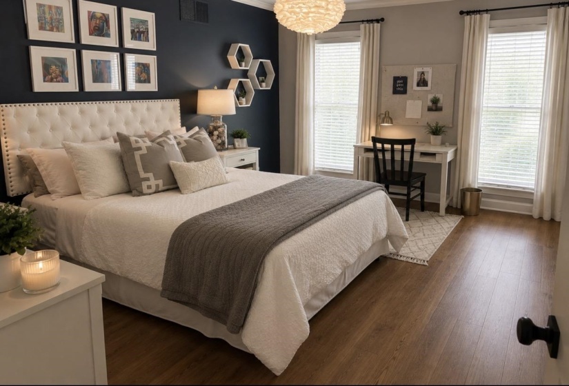 Bedroom featuring wood-finish flooring, a tufted headboard, and dual windows with blinds