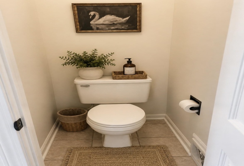 Recessed toilet paper holder, ceramic tile flooring, and a white toilet