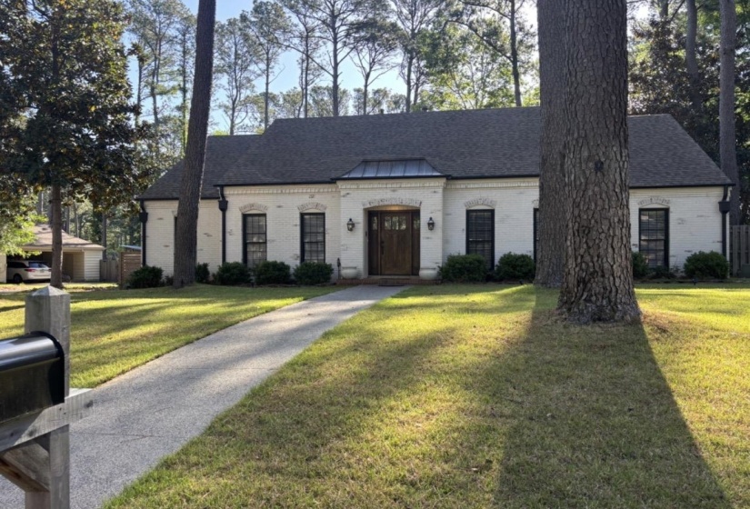 White brick exterior with a dark gray shingle roof and black window frames