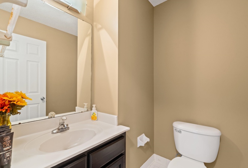 Bathroom vanity with an integrated sink, polished chrome faucet, and dark wood-finish cabinetry