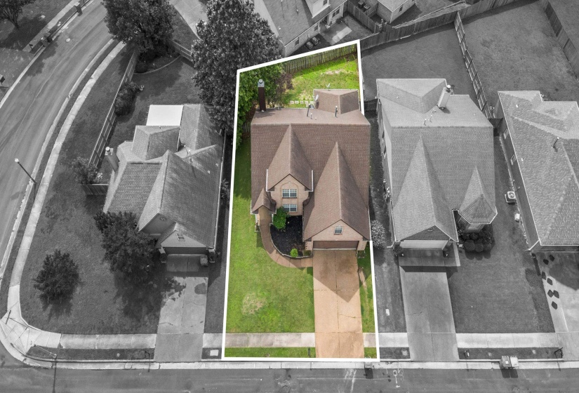 Aerial perspective highlighting the property with a distinct roofline and a well-maintained front lawn
