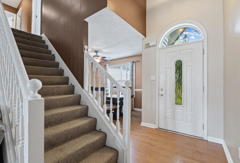 Foyer entry featuring a white paneled door with an arched transom window and decorative glass insert