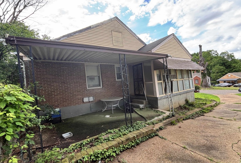 Rear exterior featuring brick siding, a covered patio, and a screened-in porch
