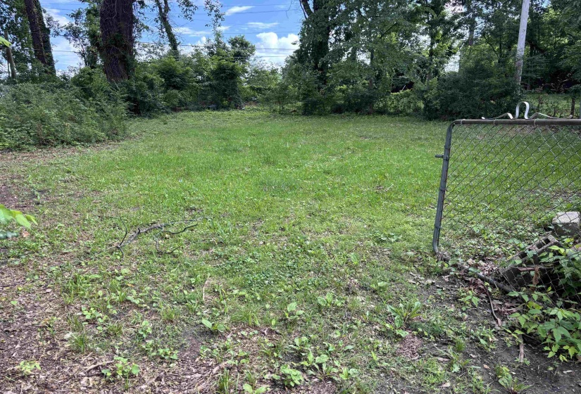 Expansive lot featuring a chain-link fence and a grassy area