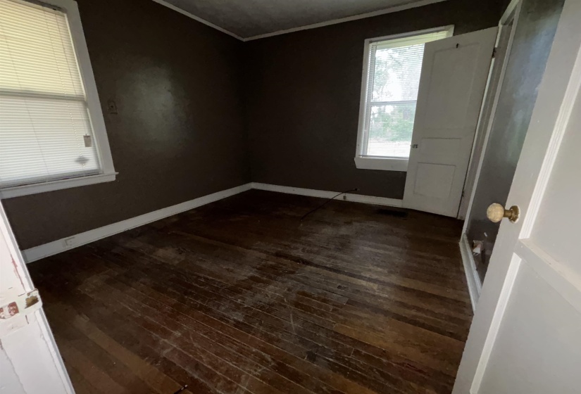 Hardwood flooring in a dark finish, contrasting with white trim and baseboards