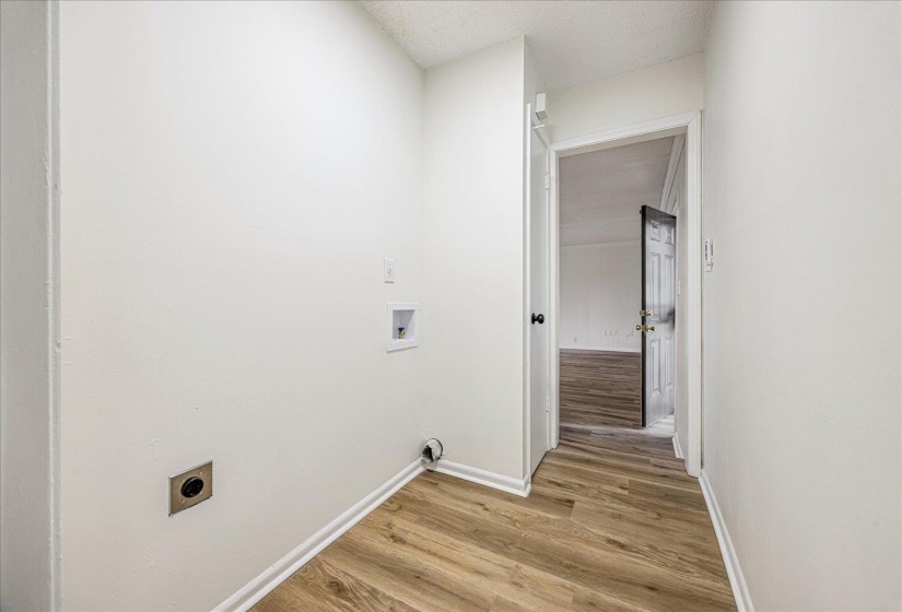 Laundry area featuring light wood finished floors, hookup for a washing machine, a textured ceiling, and hookup for an electric dryer