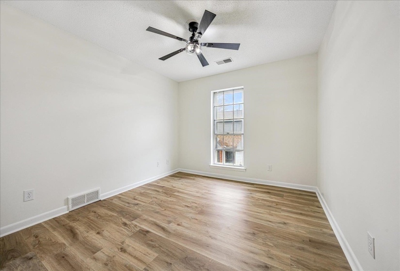 Unfurnished room featuring light wood finished floors, a textured ceiling, and a ceiling fan