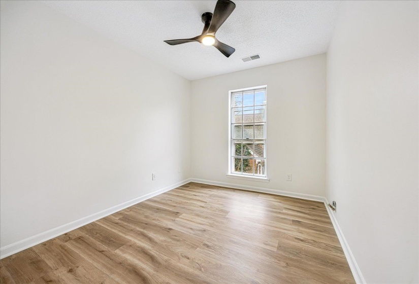 Spare room featuring light wood-style floors, a textured ceiling, and ceiling fan