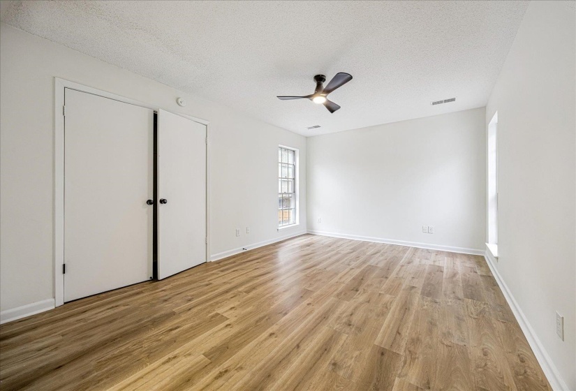 Unfurnished bedroom featuring a textured ceiling, light wood-type flooring, ceiling fan, and a closet