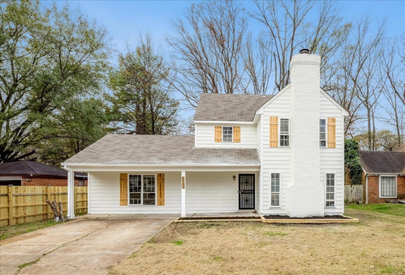 Traditional-style home with a porch, roof with shingles, a chimney, and driveway