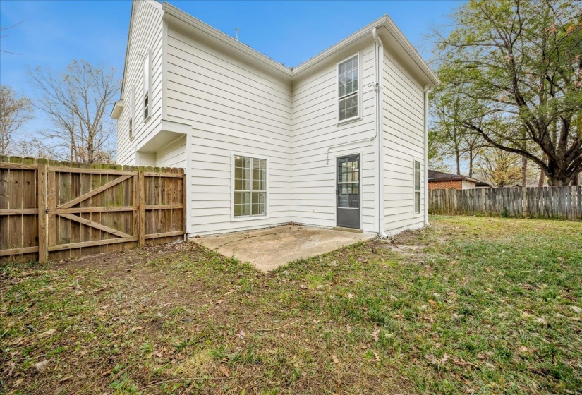 Rear view of house featuring a patio area, a fenced backyard, and a gate