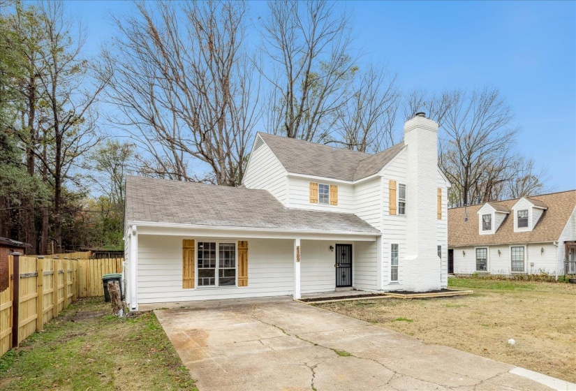 Traditional-style home featuring covered porch, a shingled roof, a chimney, and concrete driveway