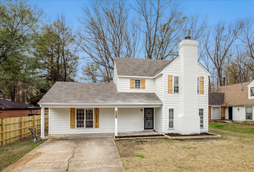 Traditional home with a porch, roof with shingles, a chimney, and driveway