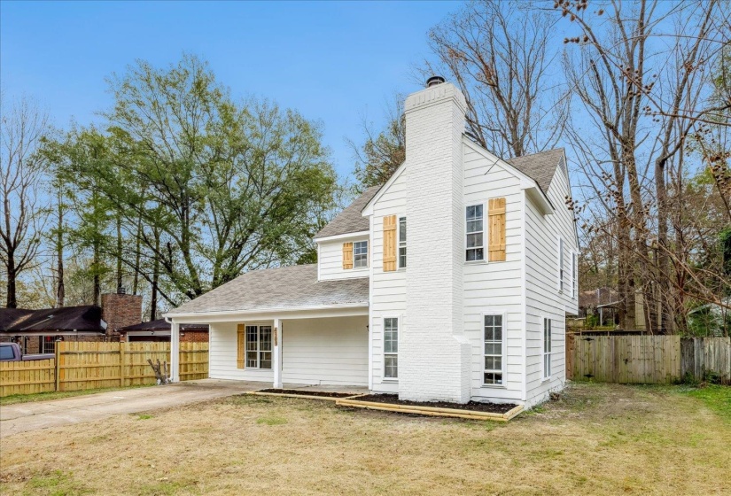 View of front facade featuring a fenced backyard, roof with shingles, a chimney, and a porch