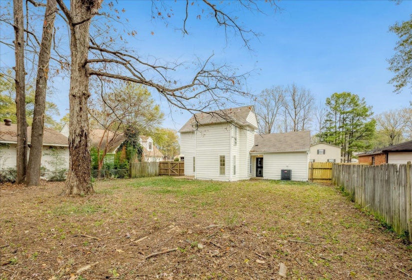 Back of property with a fenced backyard and a shingled roof