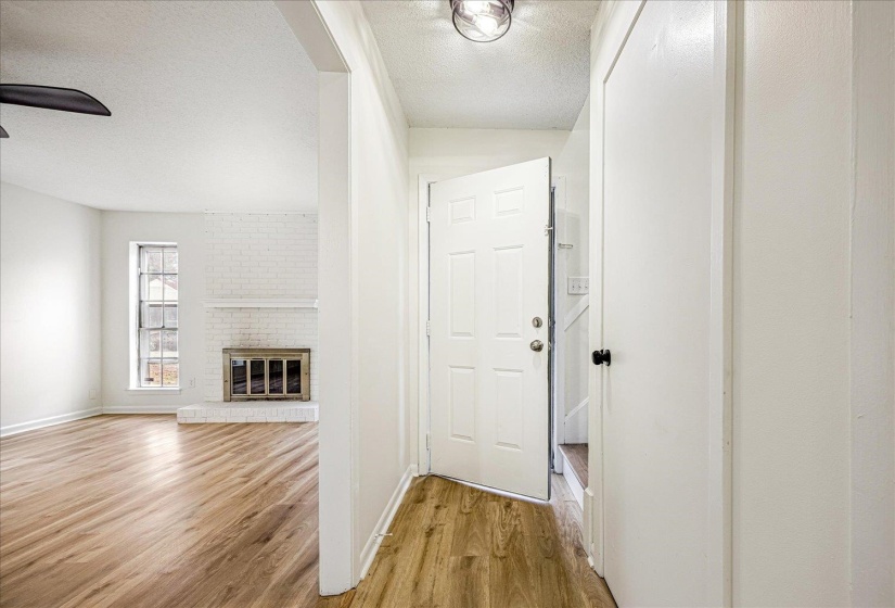 Hallway featuring a textured ceiling and light wood-type flooring