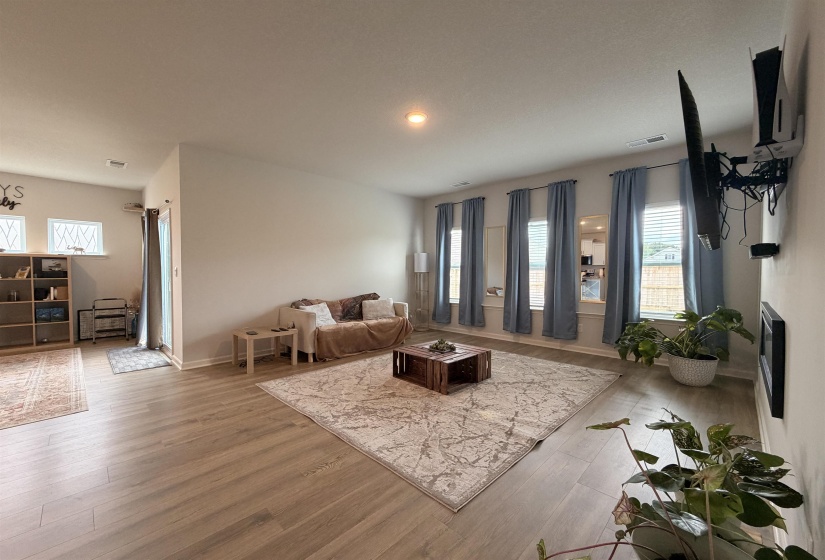 Spacious living area featuring light wood-finish flooring throughout