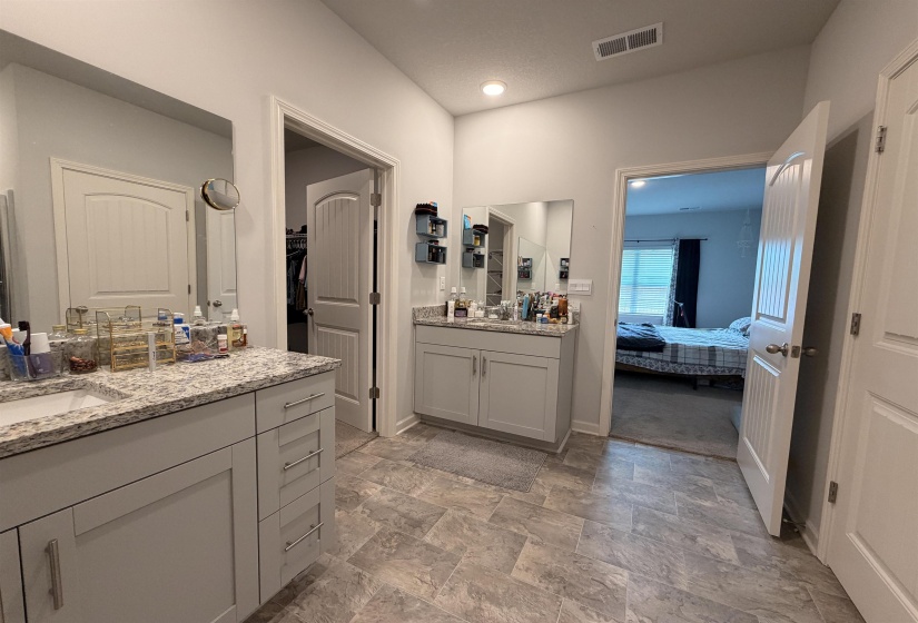 Dual vanity bathroom featuring light gray cabinetry, granite-finish countertops, and rectangular undermount sinks