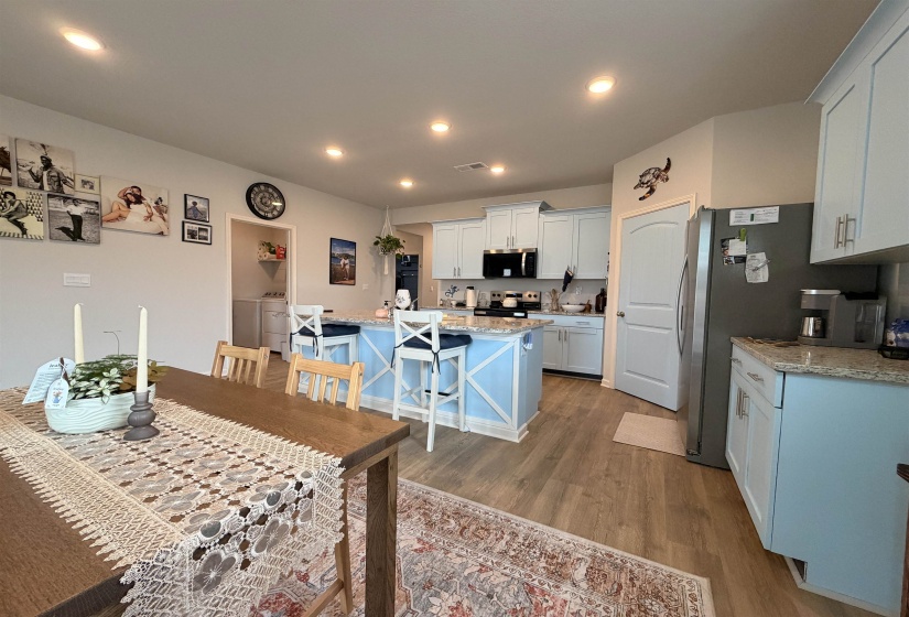 Open-concept kitchen featuring light blue cabinetry and a spacious island with bar seating