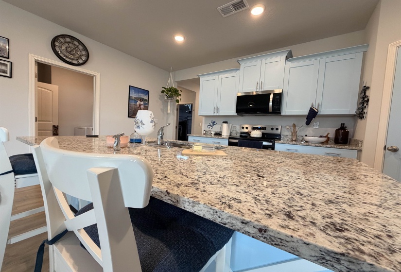 Kitchen island featuring a granite countertop with integrated sink and chrome faucet